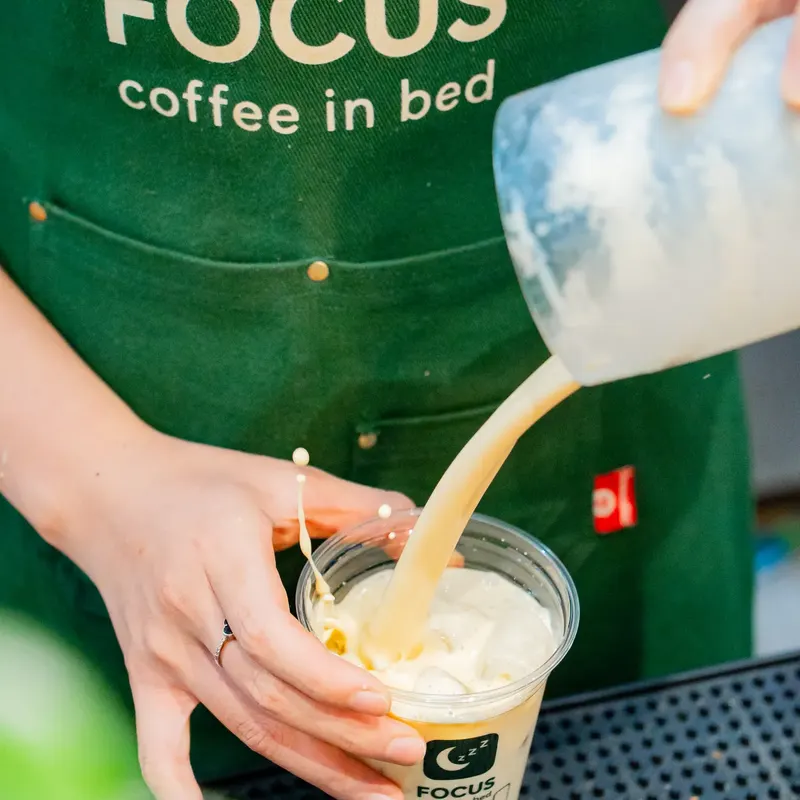 Nhân viên pha chế rót đồ uống ra ly Focus