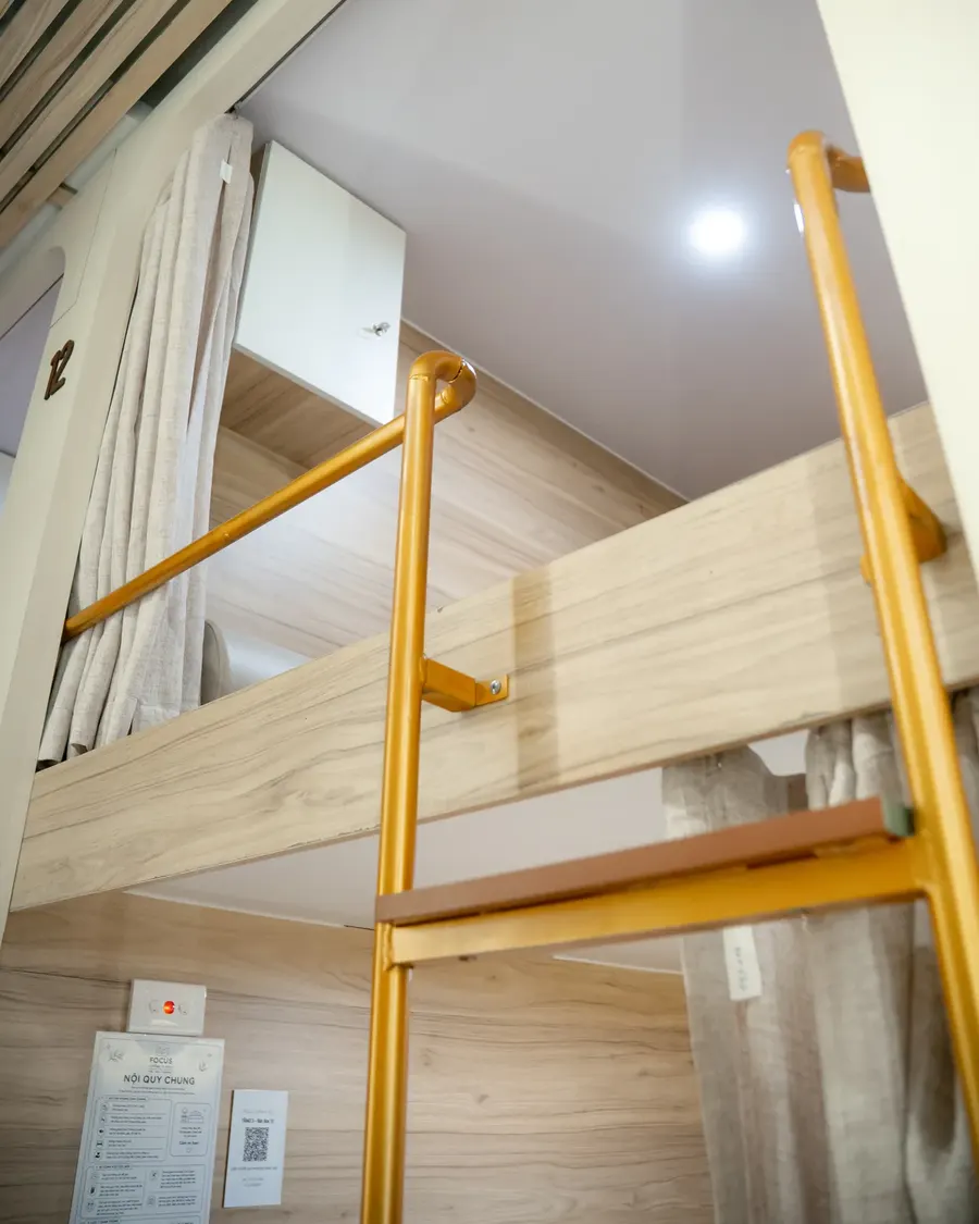 Cầu thang gỗ kết hợp thanh đồng dẫn lên box tầng 2 tại Focus
